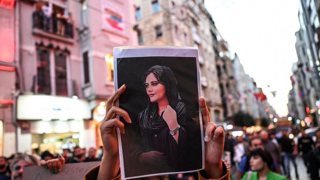 Woman holding a photograph of Slain Women&#039;s Rights Activist Mahsa Amini
